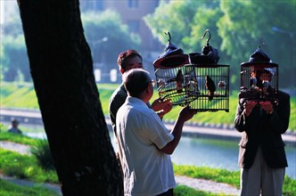 Old people walk birds in cages for fun by the river of Shenyang,Liaoning Province,China