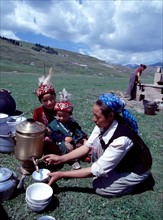 An Uygur mother prepares milk tea for her children