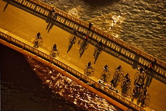 Bicycle riders on Fujianlu bridge across Suzhou river,Shanghai,China