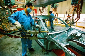 A worker welds in the workshop of Shanghai Volkswagen Automotive Company,Shanghai,China