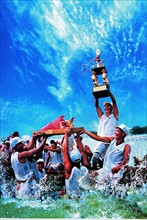 A team of people celebrate their triumph in a dragon boat race,Guangzhou,China