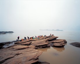 People wash cloth on the rocks, China