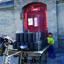 A child and a tricycle near Fuchengmen,Beijing,China