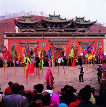 People dancing and performing at Dafuhui,a religious ceremony in front of Ta'er Lamasery,Qinghai,China