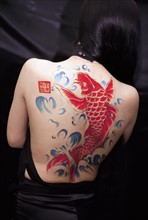 A Chinese girl with fish-shaped tattoo on her back