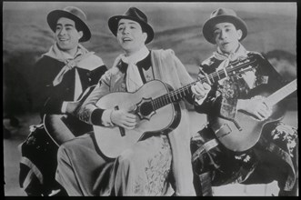 Carlos Gardel singing with two guitarists