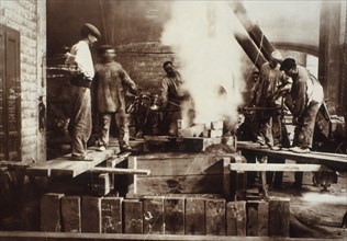 Ouvriers coulant du fer dans un moule