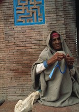 Pakistan, beggar woman performing the 'tasbih'