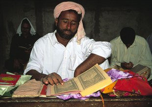 Man reading the Qur`an (Koran) in a mosque during Ramadan, Pakistan