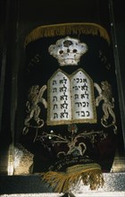 A richly embroidered mantle covers the torah, kept in the Ark
