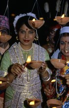 Femmes allumant des bougies à Diwani, en Inde