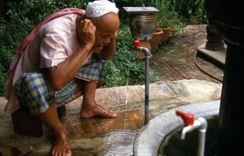 Un musulman effectuant ses ablutions avant la prière, en Malaisie