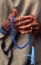 A woman outside a mosque in Pakistan saying the rosary (Tasbih)