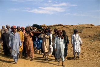 Des hommes transportent la dépouille d'un défunt à 1,5 km du cimetière de la province de Sind, au Pakistan