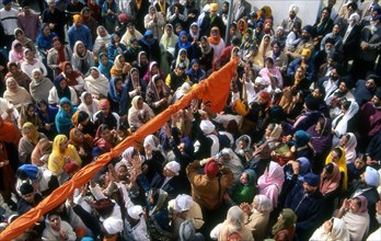 Pulling a new cover on the flagpole at Baiskahi festival, Sikh New Year, India