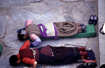 Pèlerins tibétains se prosternant devant le temple de Jokhang, temple principal de Lhassa, au Tibet