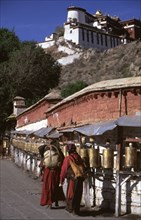 Pèlerins récitant des mantras tout agitant leurs moulins à prières, au Palais de Potala, Lassha, Tibet
