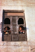Enfants à la fenêtre d'une maison de Salalah, dans le Sultanat d'Oman