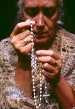 Woman using rosary beads