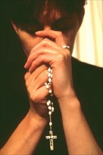 Woman praying the rosary beads