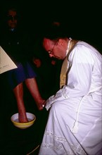 Un prête lavant les pieds d'un fidèle