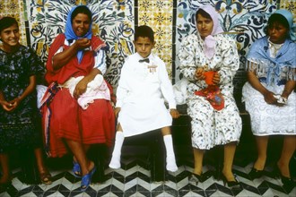 Jeune garçon venant d'être circoncis, accompagné de sa famille