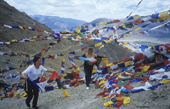 Women pilgrims hang pray flags Ganden Monastery Tibet