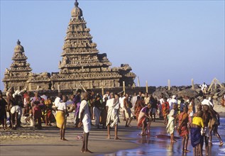 Shore temple at Mamalapuram, Tamil Nadu, with pilgrims bathing in the sea