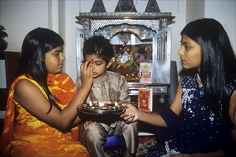 Sisters honour their young brother on Raksha Bandan or Brother`s Day in the Hindu calendar