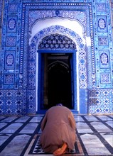 Man prays in front of the qiblah or prayer niche