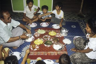 Malay family eating an iftar meal following the end of the day`s fast during the month of Ramadan