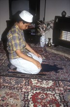 Muslim boy offers a private prayer at his home in LOndon