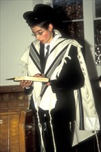 Young orthodox Jew reading the torah in a synagogue in London