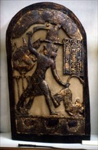 Stèle représentant le roi guidé par le faucon en position de massacre d'un fauve saisi par la queue