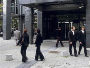 Hommes d'affaire devant l'entrée d'un immeuble de bureaux