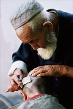 Grand-père rasant le crâne de son petit-fils