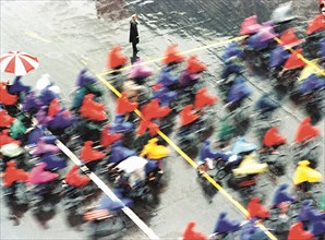 Cyclistes chinois sous la pluie
