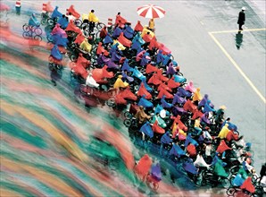 Cyclistes chinois sous la pluie