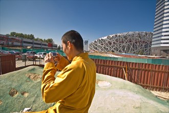Moine Shaolin photographiant le chantier du site olympique de Pékin
