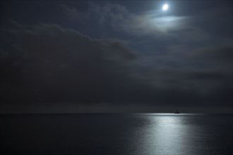 Provence357 Nuages et clair de lune la nuit sur la Méditerranée, phare rouge et voiliers blancs
