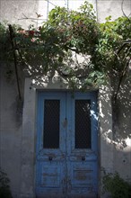 Provence558 Provence, Luberon, village, porte ancienne bleue, vigne vierge, été