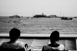 CoteAzur023 Cannes, la Croisette, les plages et la baie, yachts, deux femmes assises face à la baie