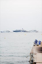 CoteAzur034 Cannes, la Croisette, plage et yachts dans la baie et le port, collines de l'Esterel