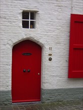 Bruges. Façade et porte rouge de maison, ruelles de la ville médiévale