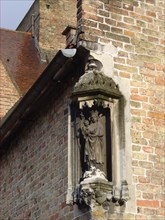Bruges. Statue de la Vierge à l'enfant , détail de façade de briques, ville médiévale