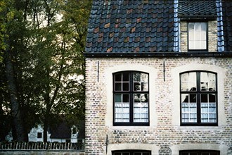 Bruges. Façade de maison des Béguines sur le Canal face au Béguinage (Begijnhof) en automne à la