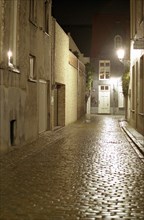 Bruges de nuit : ruelle, pavés sous la lumière des réverbères