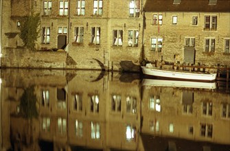 Bruges de nuit : façades, barque et reflets sur le canal