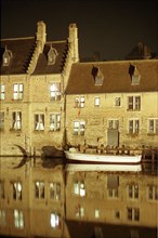 Bruges de nuit : maisons, façades, barque et reflets sur le canal