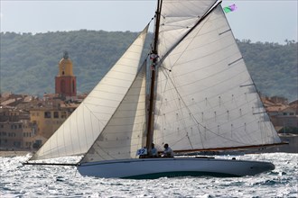 Yacht de tradition devant un village